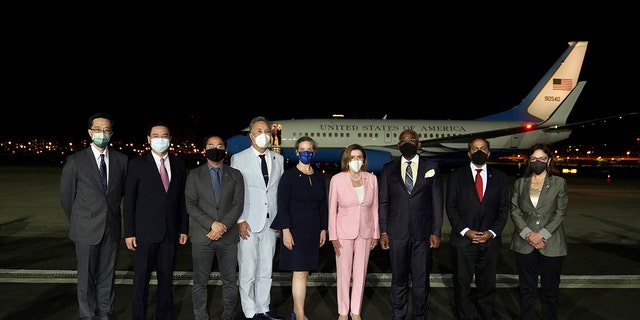 U.S. House Speaker Nancy Pelosi, center pose for photos after she arrives in Taipei, Taiwan, Tuesday, Aug. 2, 2022.