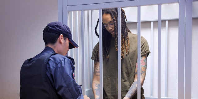 U.S. basketball player Brittney Griner stands in a defendants' cage before a court hearing during her trial on charges of drug smuggling in Khimki, outside Moscow, on Aug. 2, 2022.