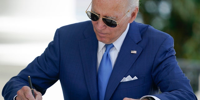 President Biden signs two bills aimed at combating fraud in the COVID-19 small business relief programs Friday, Aug. 5, 2022, at the White House in Washington.