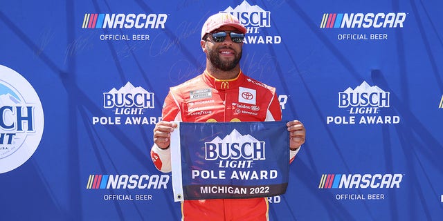 Bubba Wallace, driver of the #23 McDonald's Toyota, poses for photos after winning the pole award during qualifying for the FireKeepers Casino 400 at Michigan International Speedway, Aug. 6, 2022, in Brooklyn, Michigan.