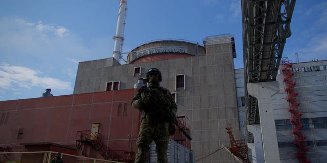 A Russian serviceman stands guard the territory outside the second reactor of the Zaporizhzhia Nuclear Power Station in Energodar on May 1, 2022.