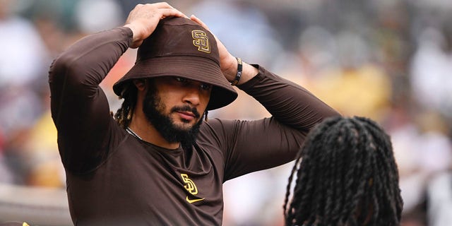 Fernando Tatis Jr., #23 of the San Diego Padres, talks with Josh Bell, #24, during a baseball game against the Colorado Rockies August 4, 2022 at Petco Park in San Diego. 