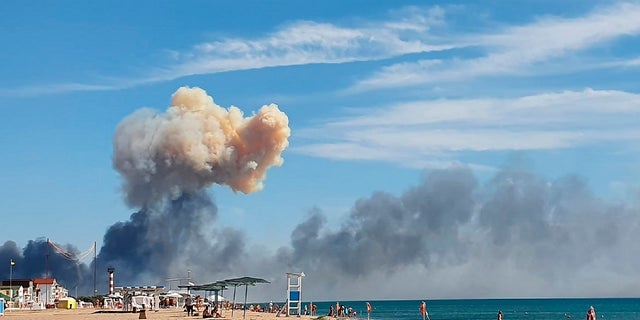 Smoke can be seen from the beach at Saki after explosions were heard from the direction of a Russian military airbase near Novofedorivka, Crimea, on Aug. 9, 2022.