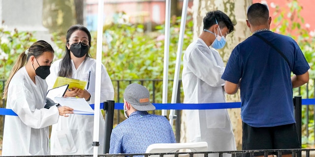 Health care workers with New York City Department of Health and Mental Hygiene help people register for the monkeypox vaccine at one of the City's vaccination sites, on Tuesday, July 26, 2022, in New York.