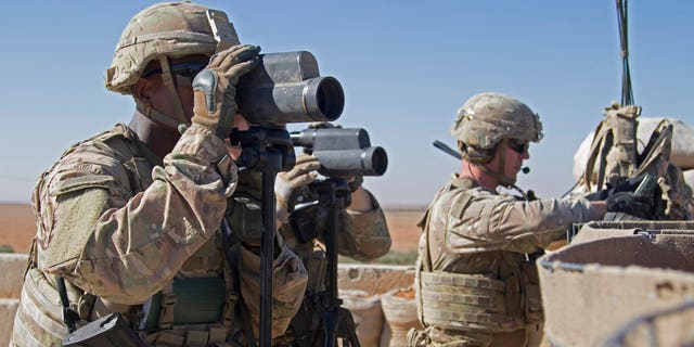 In this Nov. 1, 2018, photo released by the U.S. Army, soldiers surveil the area during a combined joint patrol in Manbij, Syria. 