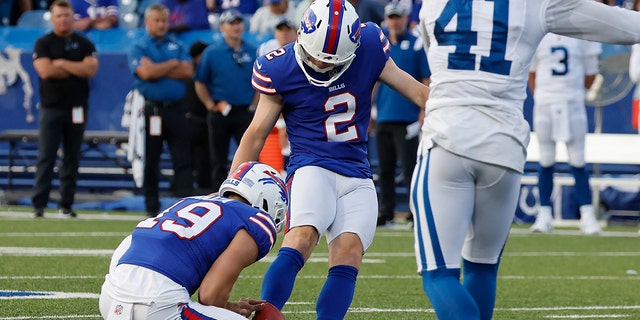 Buffalo Bills placekicker Tyler Bass boots the winning field goal as punter Matt Araiza holds the ball while Indianapolis Colts cornerback Alexander Myres tries to defend in the second half of a preseason NFL game in Orchard Park, N.Y., on Aug. 13, 2022.