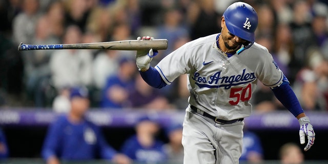 Los Angeles Dodgers' Mookie Betts tosses his bat after connecting for an RBI-single off Colorado Rockies relief pitcher Alex Colome in the eighth inning of a baseball game Saturday, April 9, 2022, in Denver.