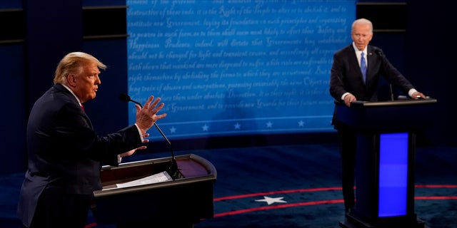 U.S. President Donald Trump answers a question as Democratic presidential candidate former Vice President Joe Biden listens during the final presidential debate at the Curb Event Center at Belmont University in Nashville, Tennessee, U.S., October 22, 2020. Morry Gash/Pool via REUTERS