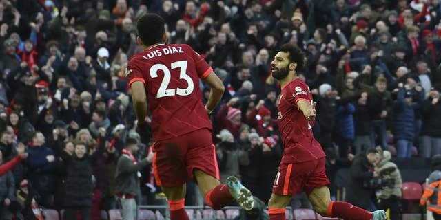 Liverpool's Mohamed Salah, right, celebrates after scoring his side's second goal during an English Premier League soccer match between Liverpool and Norwich City at Anfield Stadium in Liverpool, England, Feb. 19, 2022.