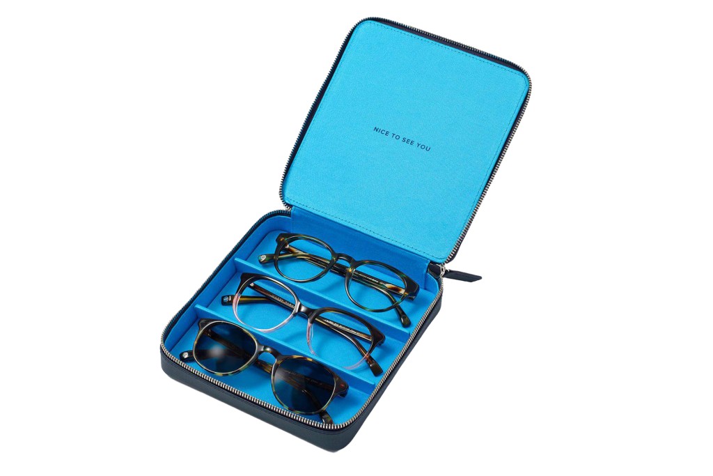 A blue case from Warby parker holding two pairs of glasses and one pair of sunglasses