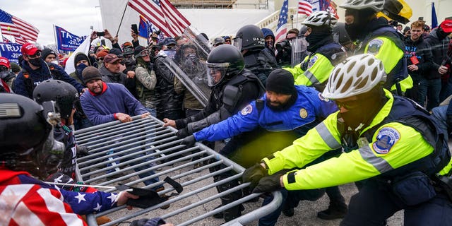 FILE - In this Jan. 6, 2021, file photo, Trump supporters try to break through a police barrier at the Capitol in Washington. Black activists are coming out strongly against a growing narrative among conservatives that equates last week’s deadly siege on the U.S. Capitol to last summer’s Black Lives Matter protests over racial injustice.