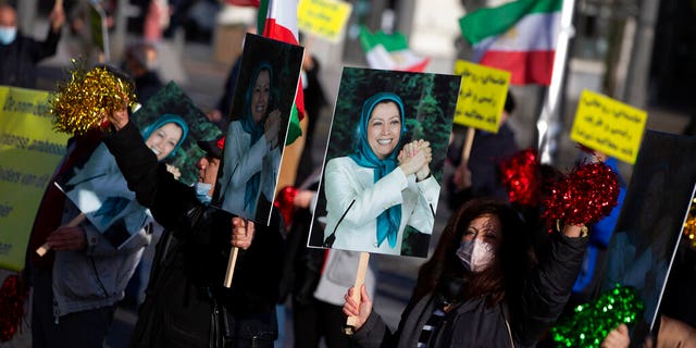 People demonstrate while holding photos of Maryam Rajavi, leader of the National Council of Resistance of Iran, during the trial of four people, including an Iranian diplomat and Belgian-Iranian couple at the courthouse in Antwerp, Belgium, Feb. 4, 2021. 