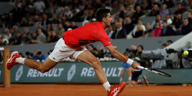 Novak Djokovic tries to return the ball to Rafael Nadal during their quarterfinal match of the French Open at the Roland Garros stadium, May 31, 2022, in Paris.