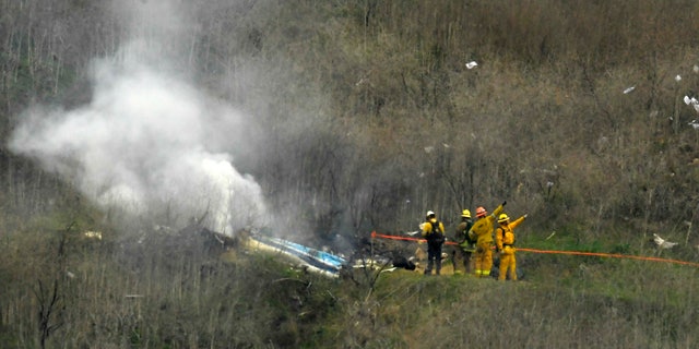 Firefighters work the scene of a helicopter crash where former NBA basketball star Kobe Bryant died in Calabasas, Calif., Jan. 26, 2020.