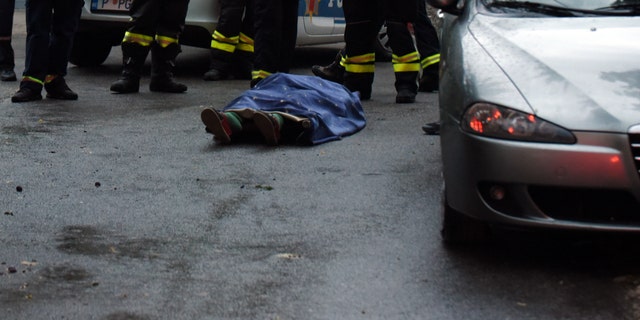 Firefighters stand by a body on the site of the attack in Cetinje, Montenegro, Friday, Aug. 12, 2022. 