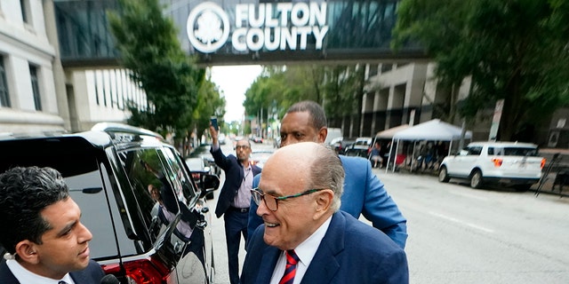 Rudy Giuliani greeted by reporters outside the Fulton County Courthouse on Wednesday, Aug. 17, 2022, in Atlanta. 