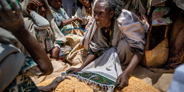 An Ethiopian woman argues with others over the allocation of yellow split peas after it was distributed by the Relief Society of Tigray in the town of Agula, in the Tigray region of northern Ethiopia on May 8, 2021.