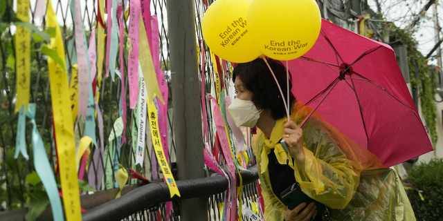 FILE - A participant watches the northern side through the barbed wire fence after a rally for peace unification of the Korean peninsula at the Imjingak Pavilion in Paju, South Korea, near the border with North Korea, Saturday, July 23, 2022. (AP Photo/Ahn Young-joon, File)