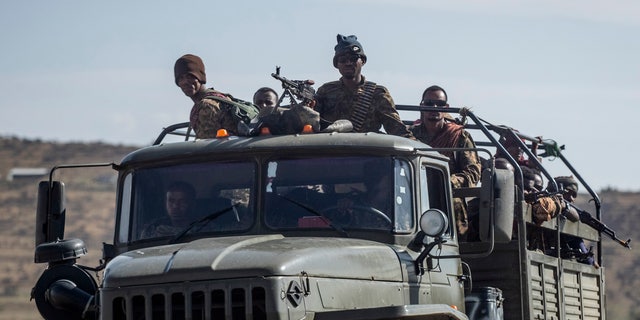 Ethiopian government soldiers ride in the back of a truck on a road near Agula, north of Mekele, in the Tigray region of northern Ethiopia on May 8, 2021.