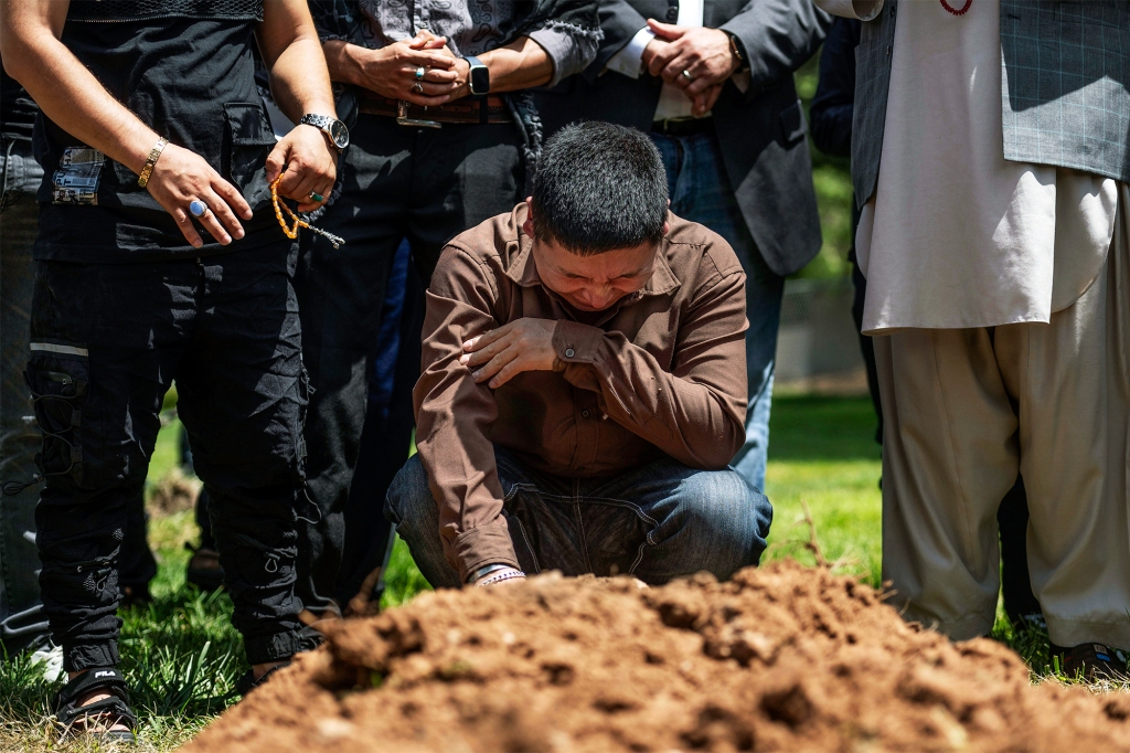 Altaf Hussain, brother of Muhammad Afzaal Hussain, cries over his grave during his burial at Fairview Memorial Park in Albuquerque, New Mexico on Aug. 5, 2022.