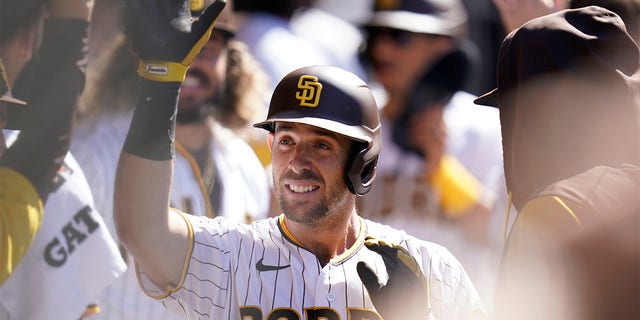 San Diego Padres' Austin Nola celebrates with teammates after scoring off a two-run double by Manny Machado during the third inning of a baseball game against the San Francisco Giants, Wednesday, Aug. 10, 2022, in San Diego. 