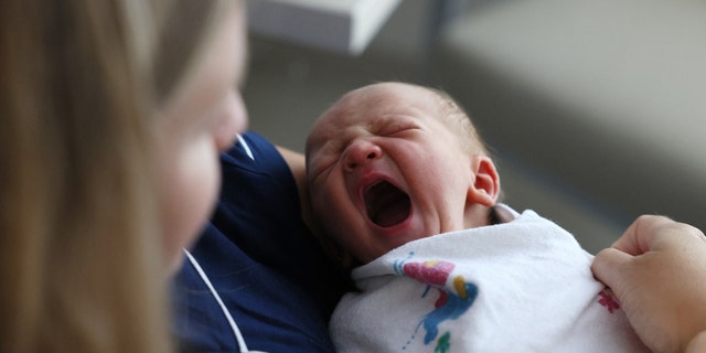 Concord, MA - July 28: A newborn baby boy yawns as he sits with his mother at Emerson Hospital. 