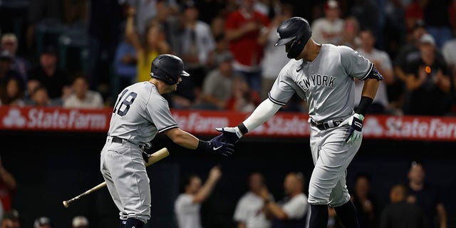 Aaron Judge, #99 of the New York Yankees, celebrates his 50th home run of the season with Andrew Benintendi, #18 against the Los Angeles Angels, during the eighth inning at Angel Stadium of Anaheim on August 29, 2022 in Anaheim, California.