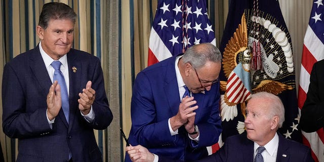 President Biden hands Sen. Joe Manchin, D-W.Va., the pen he used to sign the Inflation Reduction Act. 