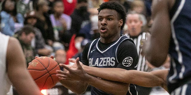 Sierra Canyons Bronny James, #0, drives the ball under pressure of Corona Centennial boys basketball team in the Southern California Open Division regional basketball finals on Tuesday, March 8, 2022 in Corona, California.