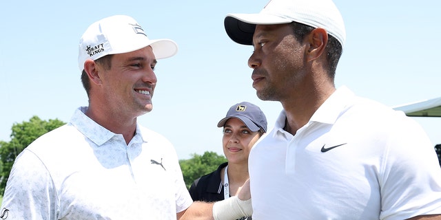 Bryson DeChambeau of the United States talks with Tiger Woods of the United States during a practice round prior to the start of the 2022 PGA Championship at Southern Hills Country Club on May 18, 2022 in Tulsa, Oklahoma.