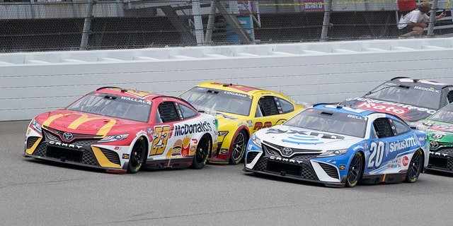 Bubba Wallace (23) races Joey Logano (yellow) and Christopher Bell (20) in the race at Michigan International Speedway in Brooklyn, Michigan, Aug. 7, 2022.