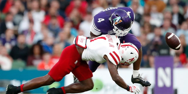 Northwestern running back Cam Porter (4) fumbles the ball as he is tackled by Nebraska defensive back Marques Buford (1) during the second half of an NCAA college football game, Saturday, Aug. 27, 2022, at Aviva Stadium in Dublin, Ireland.