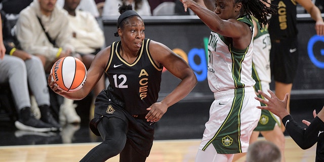 Las Vegas Aces guard Chelsea Gray (12) passes around Seattle Storm's Tina Charles during the first half of a WNBA basketball game Sunday, Aug. 14, 2022, in Las Vegas.