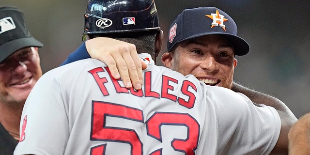 Houston Astros' Christian Vazquez, right, hugs Boston Red Sox's Carlos Febles as they exchange lineups before a game on Tuesday, Aug. 2, 2022, in Houston.