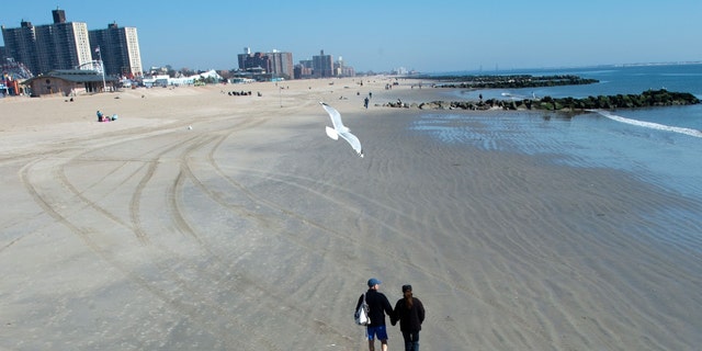 A couple walks the beach at Coney Island on March 9, 2016 in New York. 