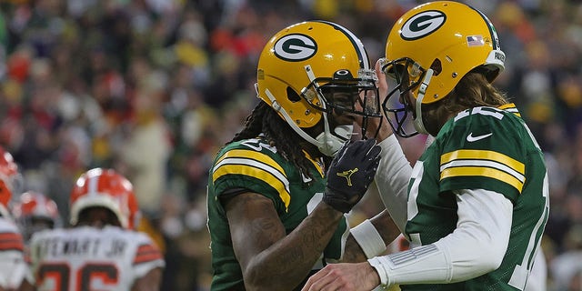 Aaron Rodgers (12) celebrates a touchdown with Davante Adams (17) of the Green Bay Packers during a game against the Cleveland Browns at Lambeau Field Dec. 25, 2021, in Green Bay, Wis. The Packers defeated the Browns 24-22.