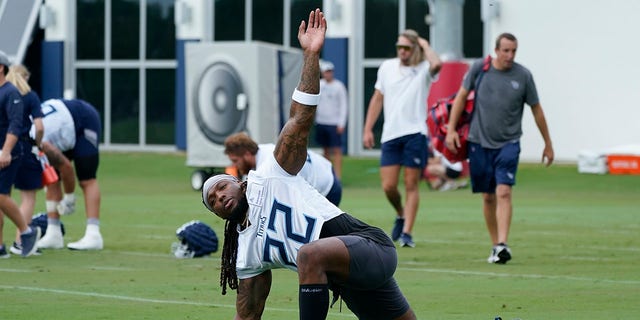 FILE - Tennessee Titans running back Derrick Henry (22) stretches during NFL football training camp July 27, 2022, in Nashville, Tenn. The NFL essentially is back to normal going into its third season dealing with COVID-19. All the protocols devised and tweaked by the league and the NFL Players Association that all 32 teams followed through 2020 and 2021 were suspended last March, with the NFL citing trends showing the spread of the coronavirus declining.