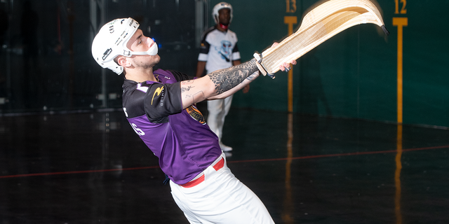 Matthew Langhans throws the pelota against the wall.