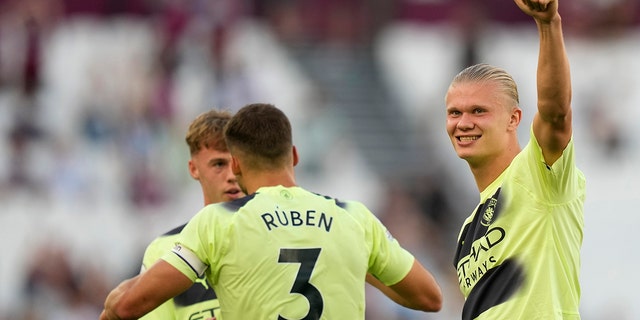 Manchester City's Erling Haaland, right, celebrates after the English Premier League match against West Ham United at London Stadium in London, England, Aug. 7, 2022.