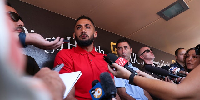 San Diego Padres' Fernando Tatis Jr., center, speaks to the media about his 80-game suspension from baseball, Aug. 23, 2022, in San Diego, California.