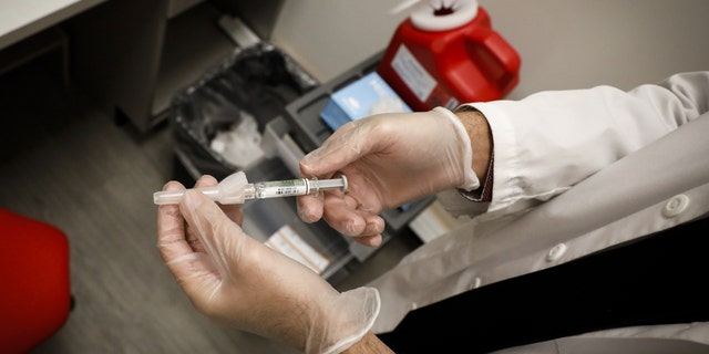 A pharmacist prepares a free flu shot vaccine at a CVS Health Corp. Pharmacy in Miami, Florida, U.S., on Wednesday, Sept. 30, 2020. 