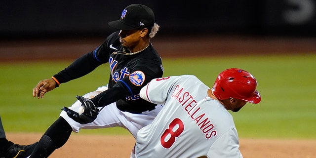 Philadelphia Phillies' Nick Castellanos, #8, slides past New York Mets' Francisco Lindor, left, to steal second base during the eighth inning of a baseball game Friday, Aug. 12, 2022, in New York.