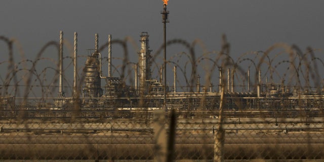 A flame burns off waste gas at Saudi Aramco's Ras Tanura oil refinery and terminal in Ras Tanura, Saudi Arabia in October 2018.