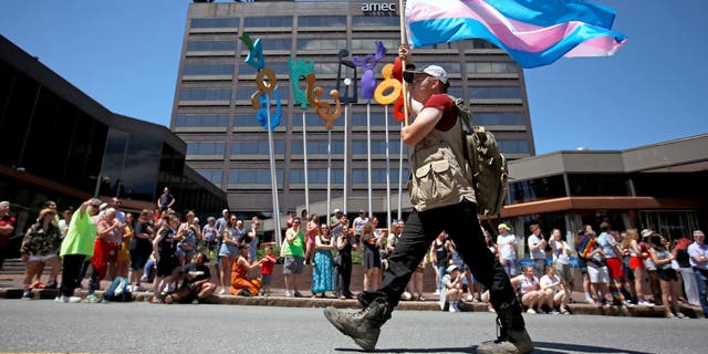 File photo of a person carrying a trans pride flag. Sikes had generated millions of views on TikTok during Alabama Rush Week by documenting the recruitment journey.