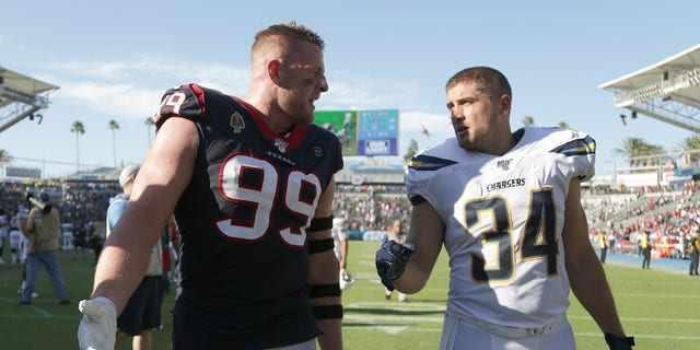 J.J. Watt (99) of the Houston Texans and brother Derek Watt (34) of the Los Angeles Chargers walk off the field following the Texans' 27-20 victory over the Chargers at Dignity Health Sports Park Sept. 22, 2019, in Carson, Calif. 