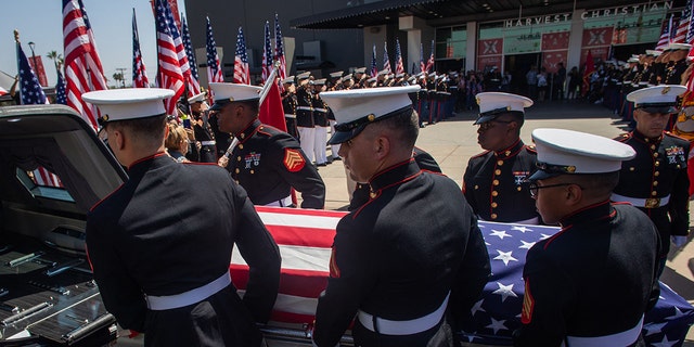 A military honor guard carries the flag-draped casket of Marine Lance Cpt. Kareem Grant Nikoui at the Harvest Christian Fellowship on September 18, 2021, in Riverside, California. 