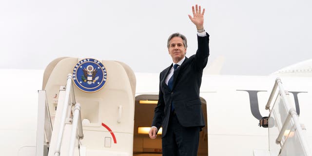 Secretary of State Antony Blinken waves as he boards a plane to depart from the Algerian capital of Algiers on March 30, 2022