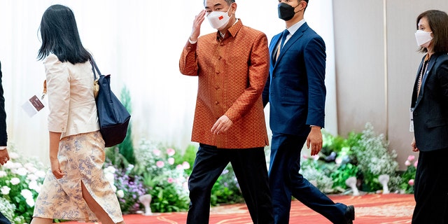 Chinese Foreign Minister Wang Yi (C) arrives at ASEAN gala dinner at the Chroy Changvar International Convention and Exhibition Center in Phnom Penh on August 4, 2022. 