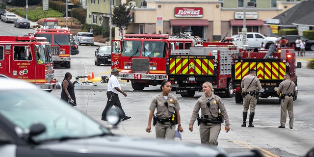 Members of the Los Angeles County Fire Department, CHP and other officials investigate a fiery crash where multiple people were killed near a Windsor Hills gas station at the intersection of West Slauson and South La Brea avenues on Aug. 4, 2022, in Los Angeles, California.