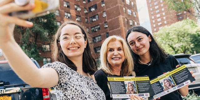 Rep. Carolyn Maloney, a Democrat from New York, center, takes a selfie with volunteers for social media in New York on Aug. 7, 2022.